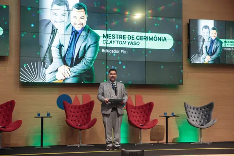 Palco do CONAPREF com o telão “Mestre de cerimônia Clayton Yaso” e o Clayton conduzindo o evento.